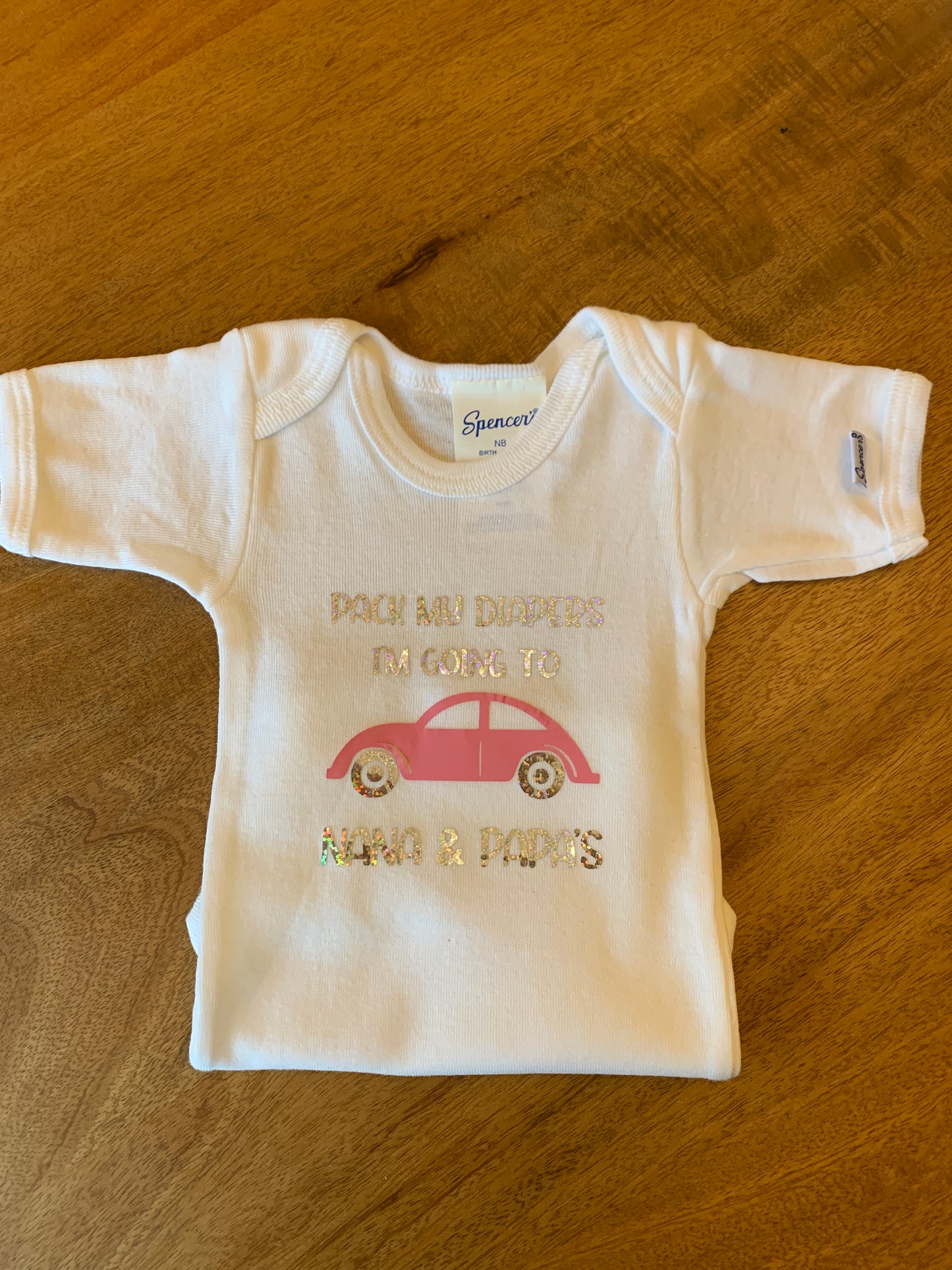 Hard to see but the glitter says Pack my diapers, I'm going to Nana & Papa's.  There is a cute little p[ink car.
